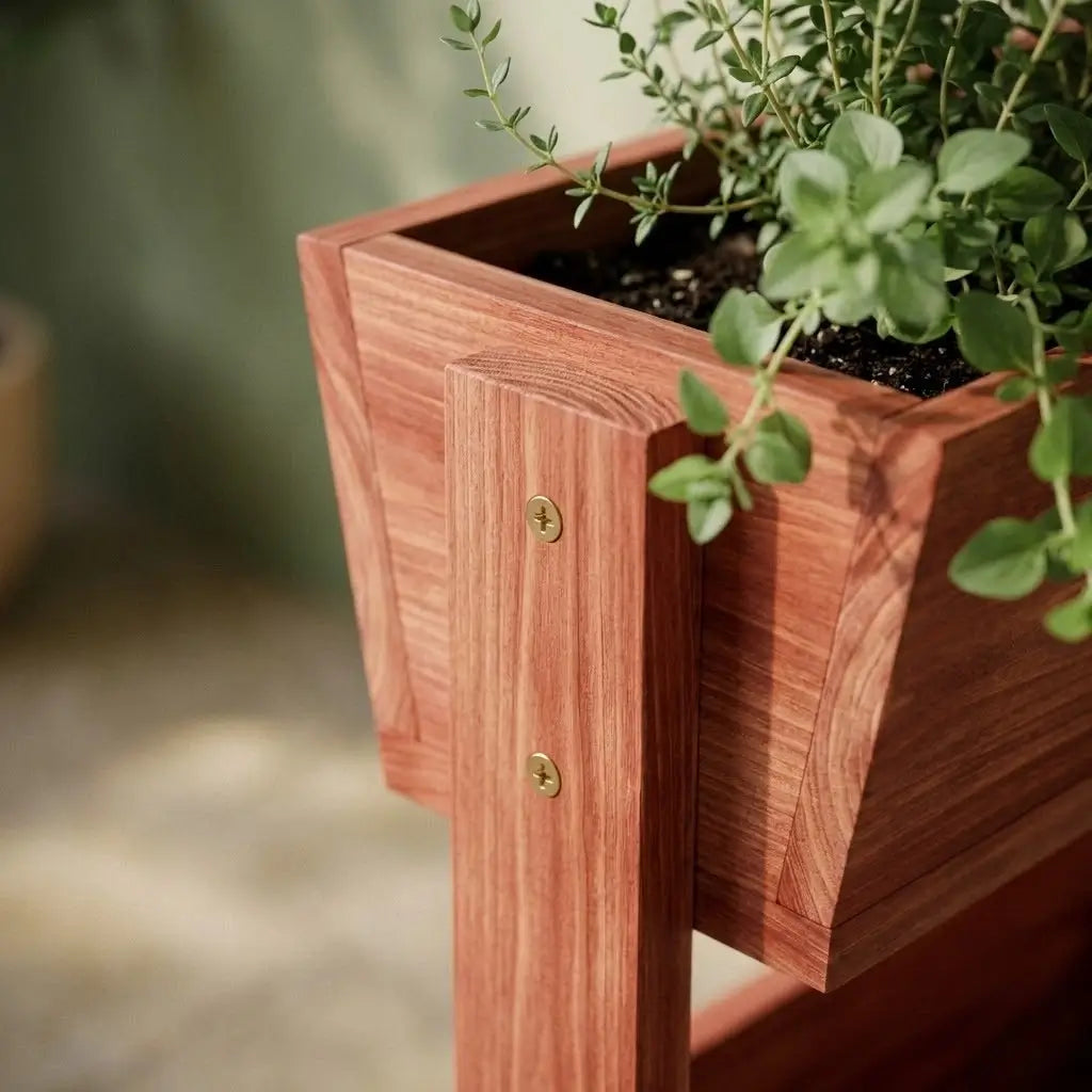 Detailaufnahme der robusten Holzkonstruktion des Balkon-Hochbeets mit goldenen Messingschrauben und Kräutern